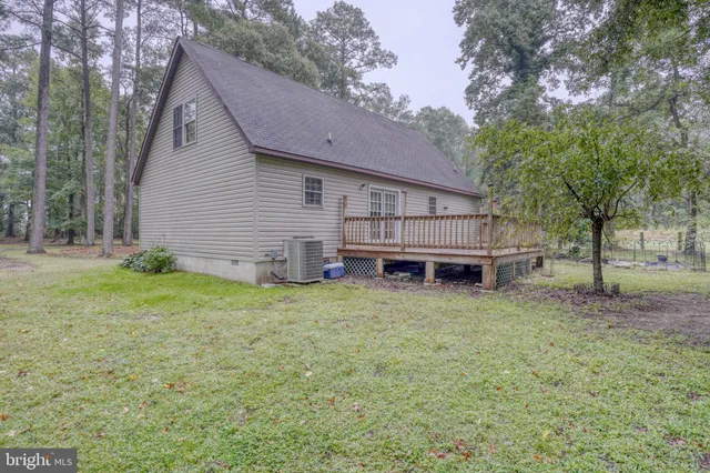 a backyard of a house with wooden fence and large trees
