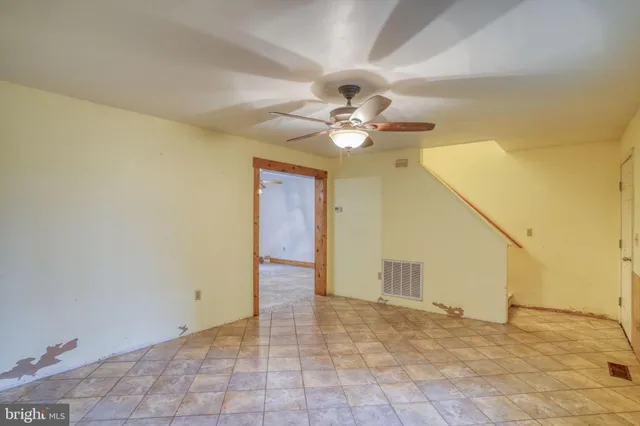a view of an empty room with a chandelier fan