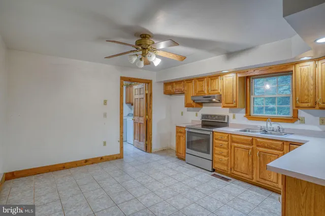 a kitchen with granite countertop a sink cabinets stainless steel appliances and a counter top space