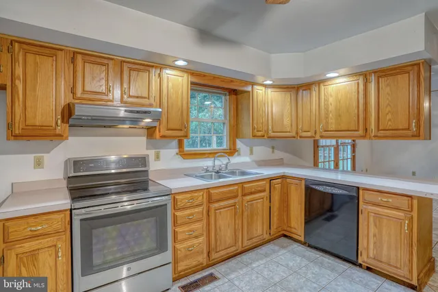 a kitchen with appliances a sink and cabinets
