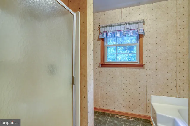 a bathroom with a window and a shower