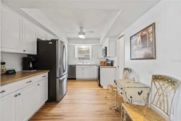a kitchen with a refrigerator a sink and dishwasher with wooden floor