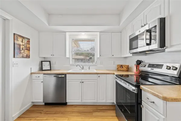 a kitchen with stainless steel appliances granite countertop a sink stove and cabinets
