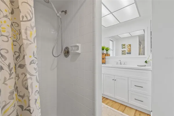 a bathroom with a sink a mirror and a shower