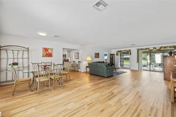 a living room with furniture floor to ceiling window and wooden floor