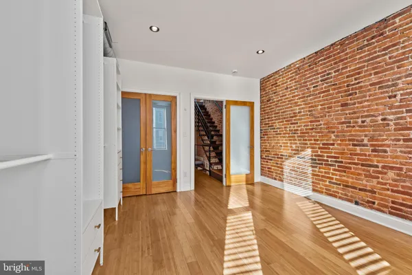 a view of a hallway with wooden floor and staircase