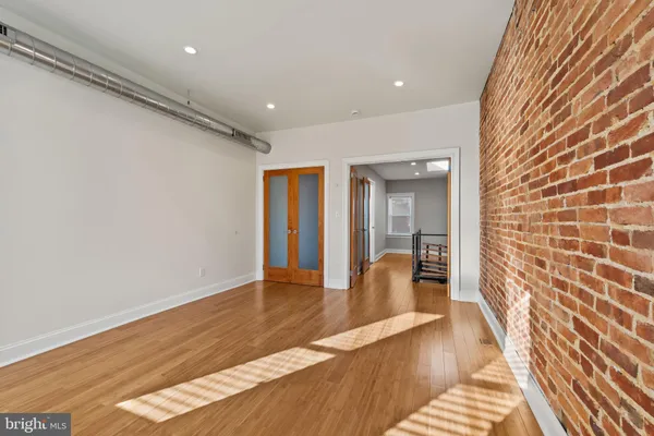 a hallway with wooden floor and mirror
