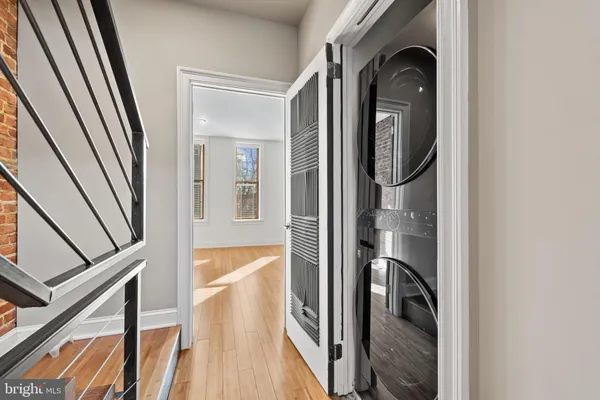 a view of a hallway with wooden floor and staircase