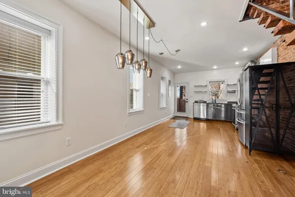 a view of empty room with wooden floor and windows