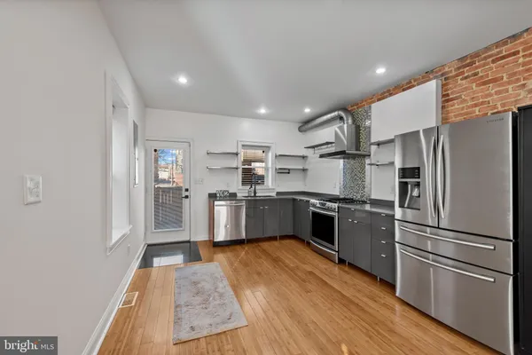 a kitchen with stainless steel appliances a refrigerator and a stove top oven