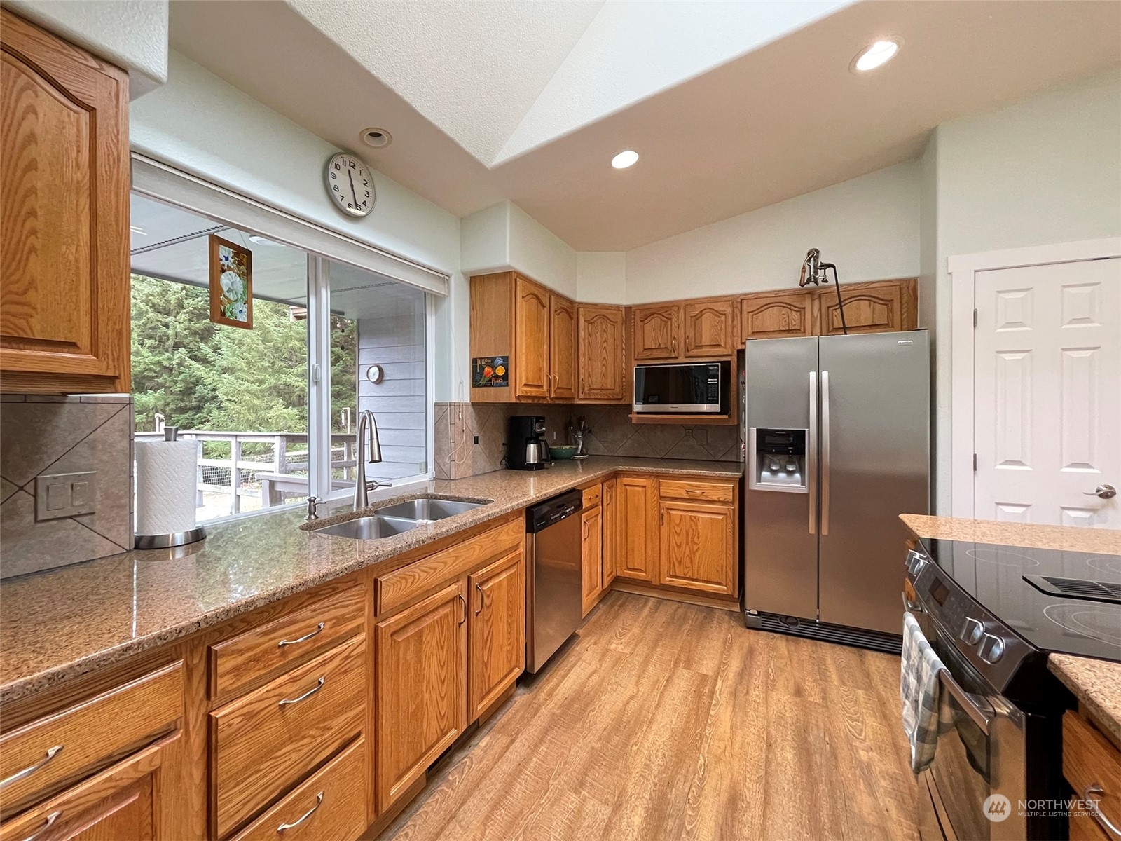 61 Sunny Dell Lane Sequim, WA 98382 - Photo 11 of 40 a large kitchen with a large window a sink and stainless steel appliances