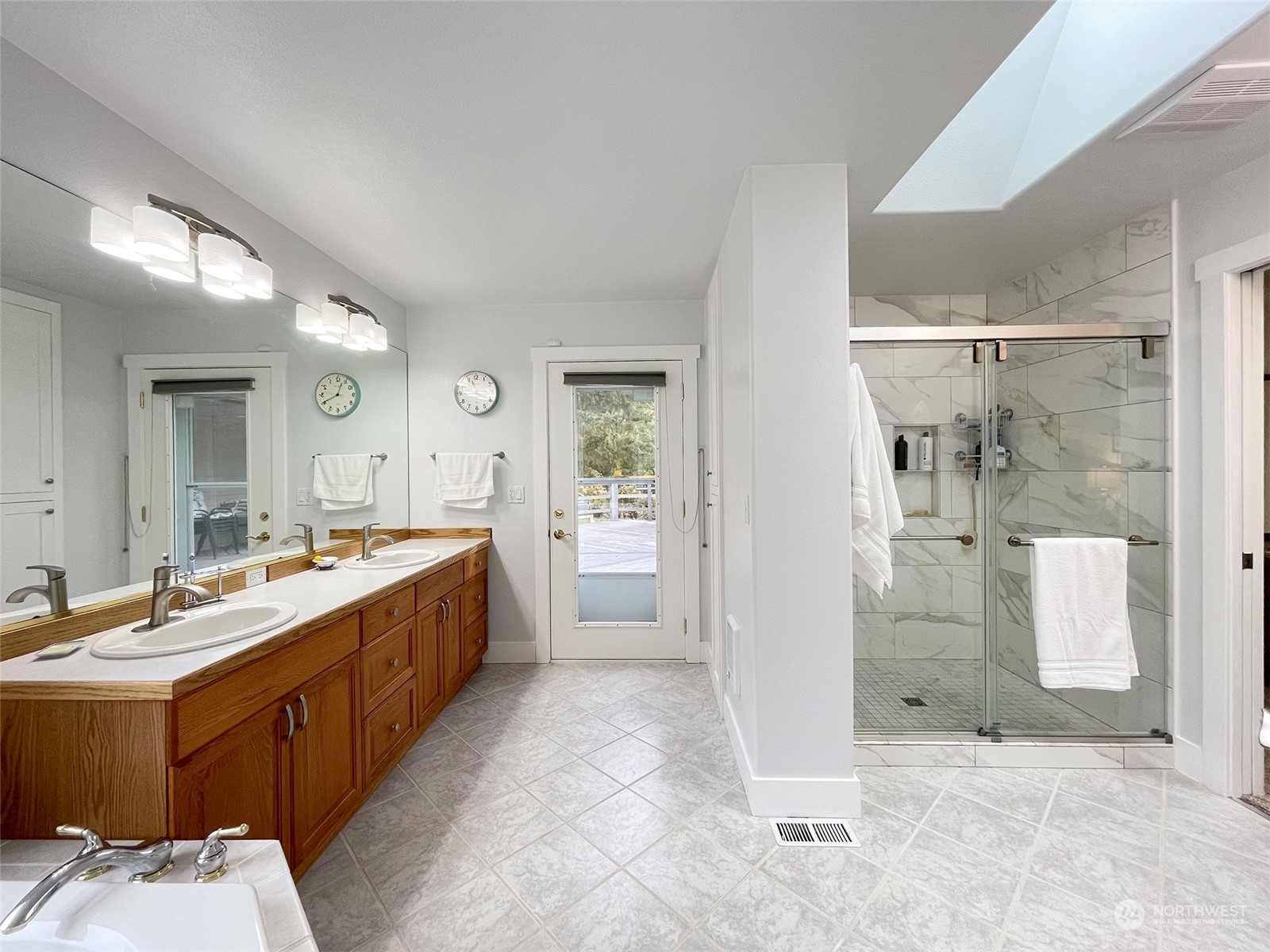 61 Sunny Dell Lane Sequim, WA 98382 - Photo 24 of 40 a large bathroom with a double vanity sink toilet mirror and bathtub