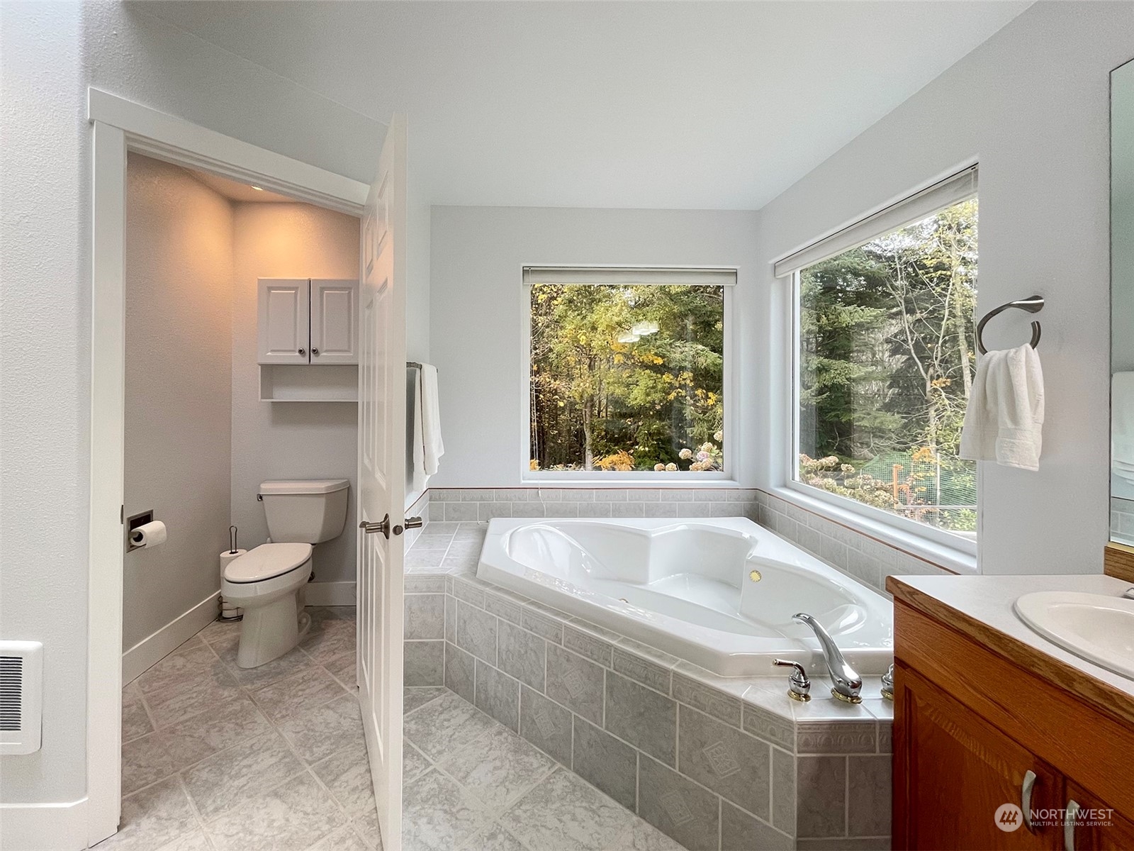 61 Sunny Dell Lane Sequim, WA 98382 - Photo 26 of 40 a spacious bathroom with a granite countertop toilet a sink and a bathtub