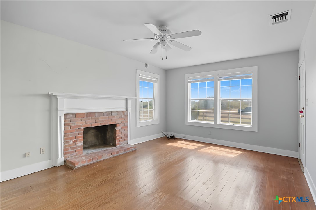 3752 Farm To Market 77 Nixon, TX 78140 - Photo 26 of 48 a view of an empty room with wooden floor fireplace and a window