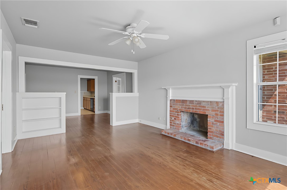 3752 Farm To Market 77 Nixon, TX 78140 - Photo 27 of 48 an empty room with wooden floor fireplace and windows