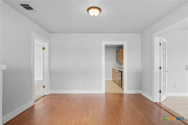 a view of an empty room with a fireplace and a window
