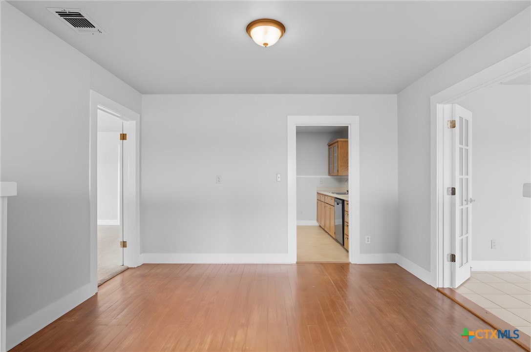 3752 Farm To Market 77 Nixon, TX 78140 - Photo 29 of 48 an empty room with wooden floor and mirror