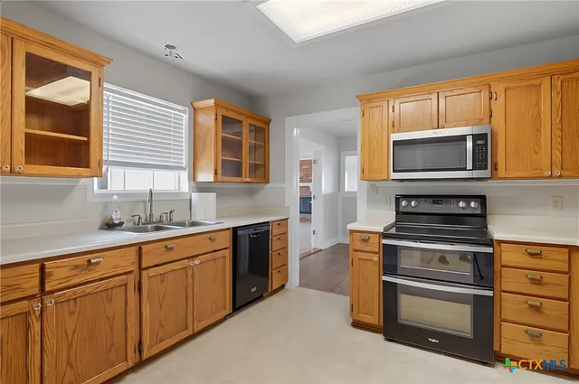 a kitchen with stainless steel appliances granite countertop a refrigerator a sink and a stove