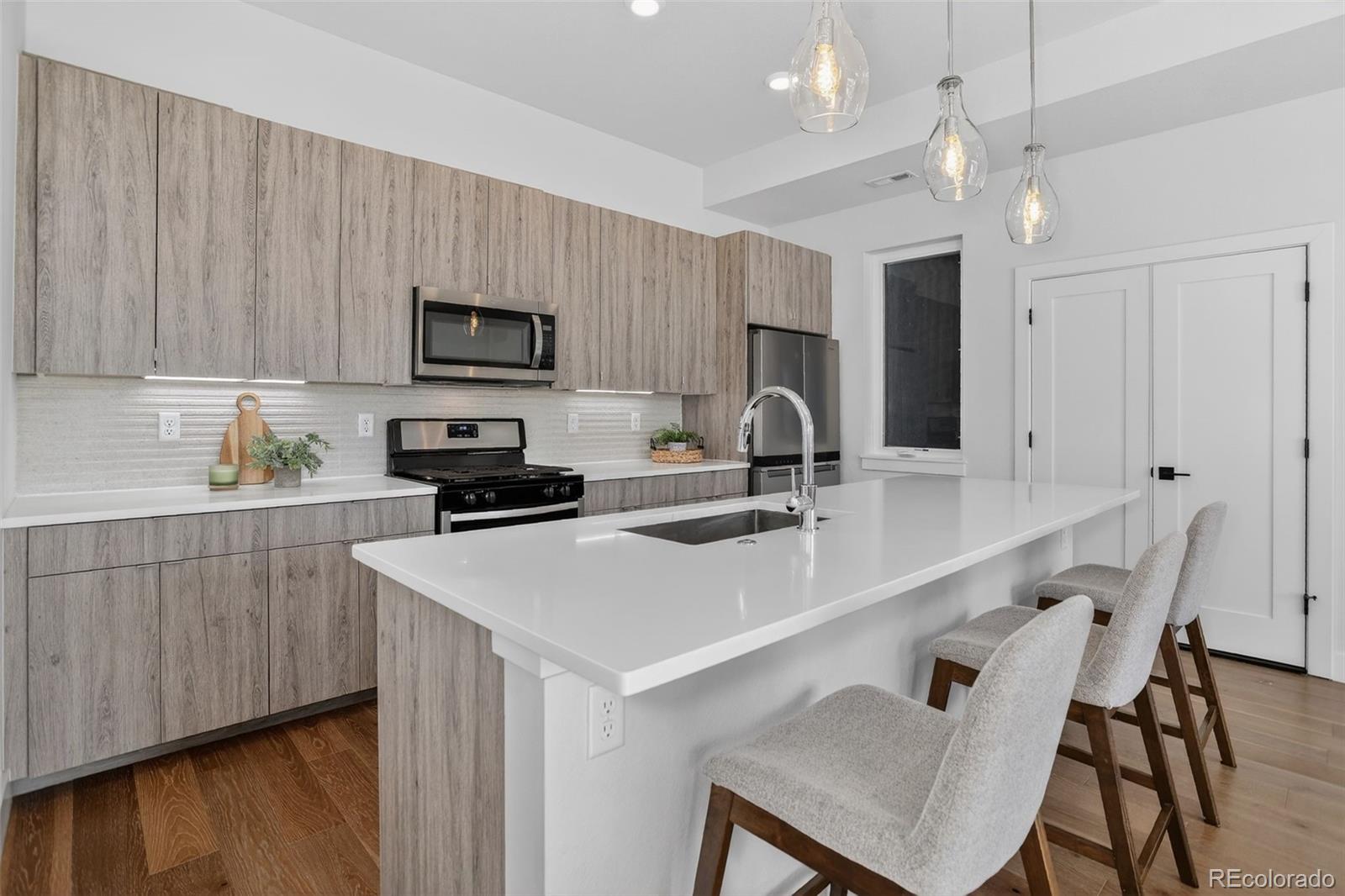 1234 Perry Street Denver, CO 80204 - Photo 6 of 29 a kitchen with a sink cabinets and wooden floor