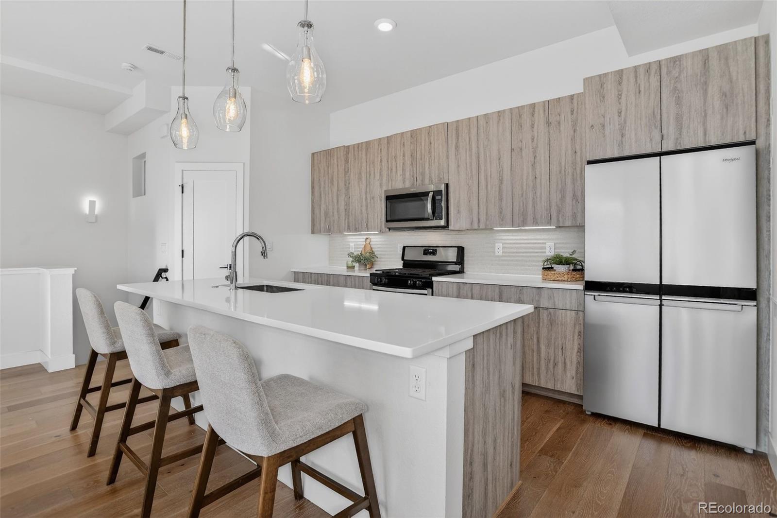 1234 Perry Street Denver, CO 80204 - Photo 7 of 29 a kitchen with kitchen island a sink stainless steel appliances and cabinets