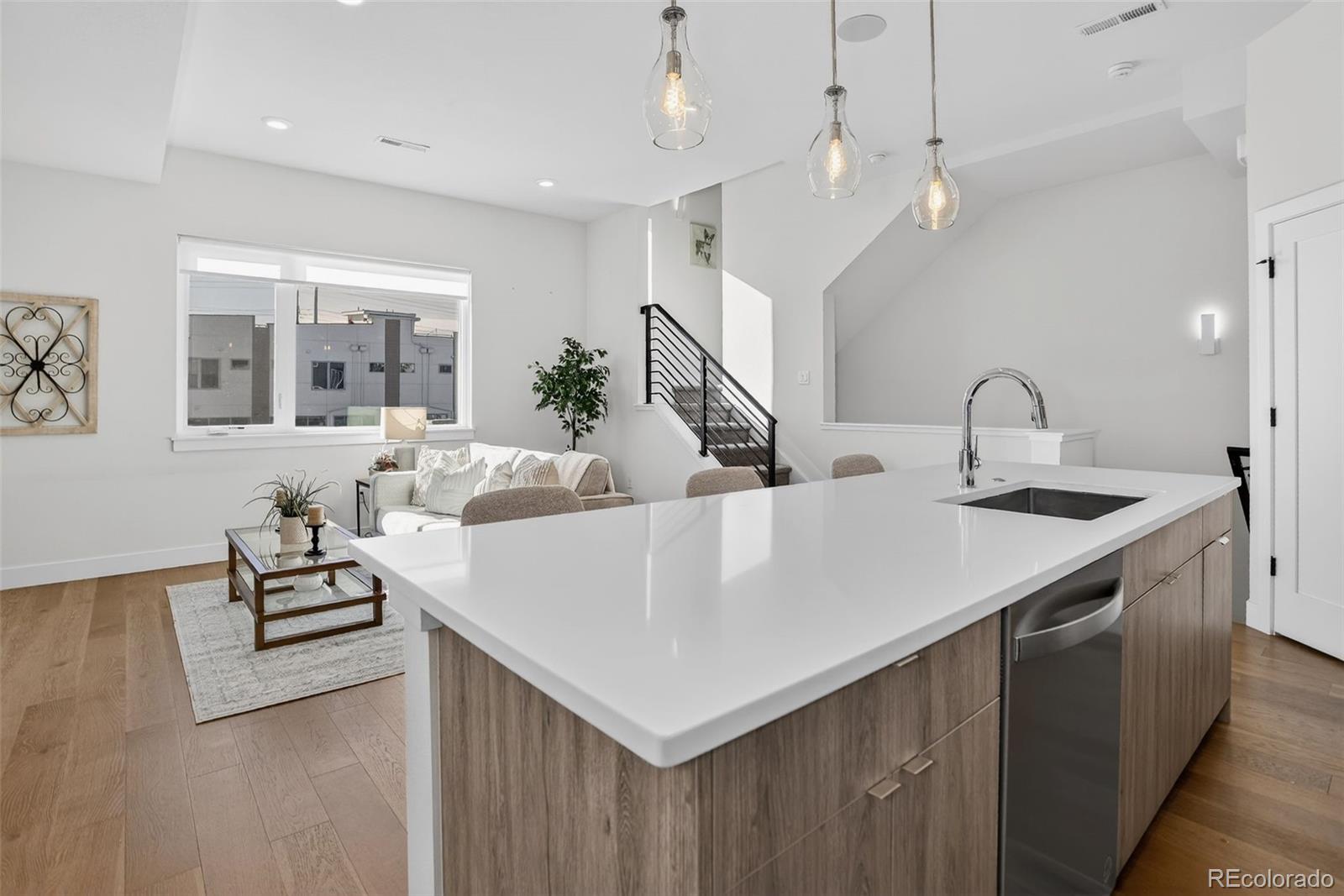 1234 Perry Street Denver, CO 80204 - Photo 8 of 29 a kitchen with a stove a sink dishwasher a dining table and chairs with wooden floor