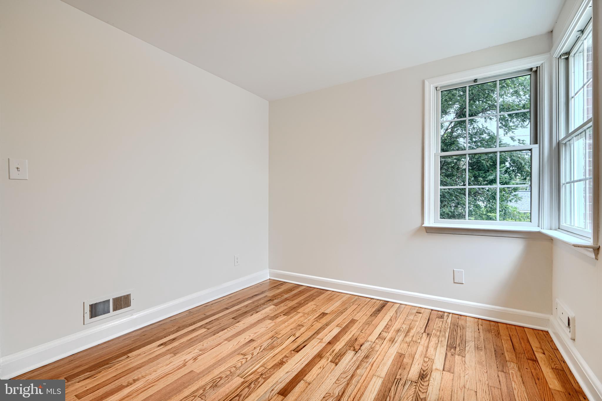 1813 Weyburn Road Baltimore, MD 21237 - Photo 15 of 39 an empty room with wooden floor and windows