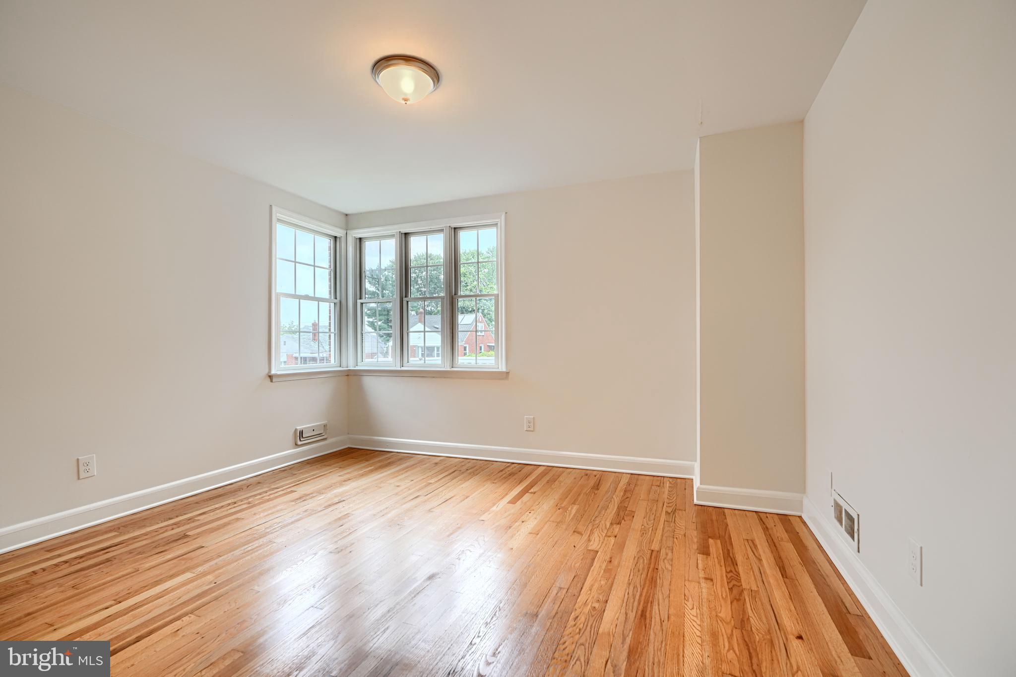1813 Weyburn Road Baltimore, MD 21237 - Photo 18 of 39 an empty room with wooden floor and windows
