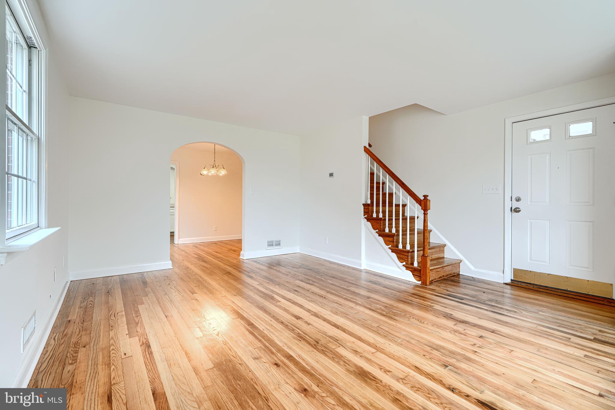 1813 Weyburn Road Baltimore, MD 21237 - Photo 7 of 39 a view of an empty room with wooden floor and a window