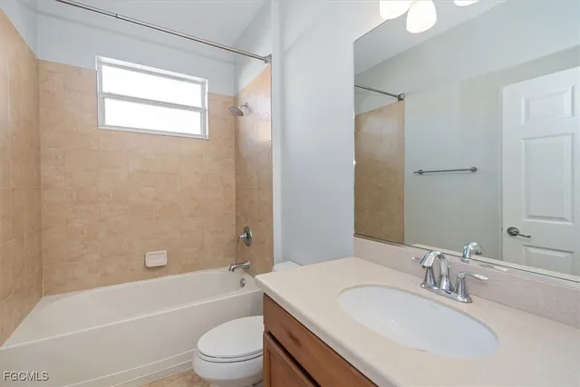 a bathroom with a bathtub shower sink vanity mirror and toilet