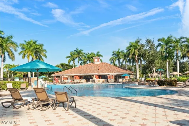 a view of patio with chairs and table under an umbrella