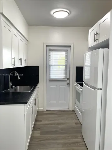 a kitchen with a refrigerator and a sink
