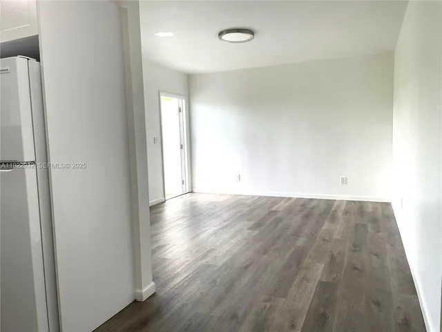 a view of a room with wooden floor and a window
