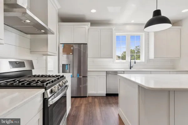 a kitchen with kitchen island a sink stainless steel appliances and window