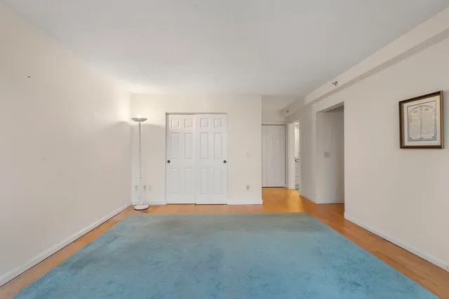 a bedroom with a bed and a lamp on the dresser