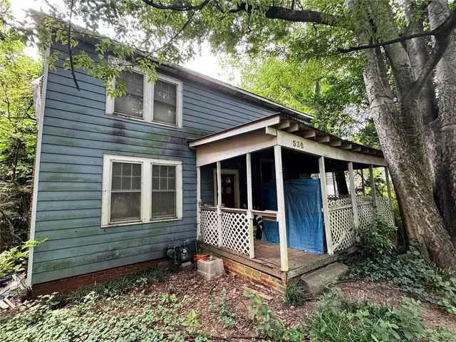 a front view of a house with glass windows and plants