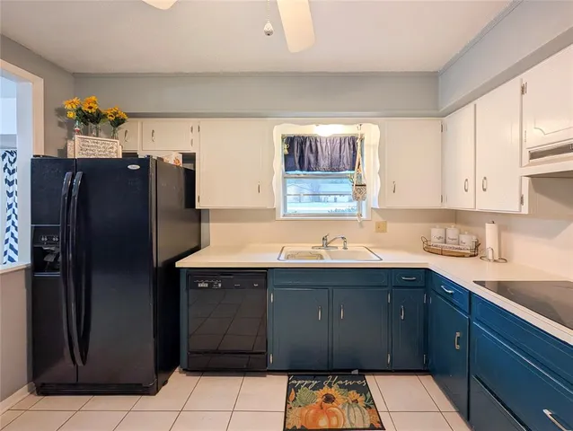 a kitchen with a sink a refrigerator and cabinets