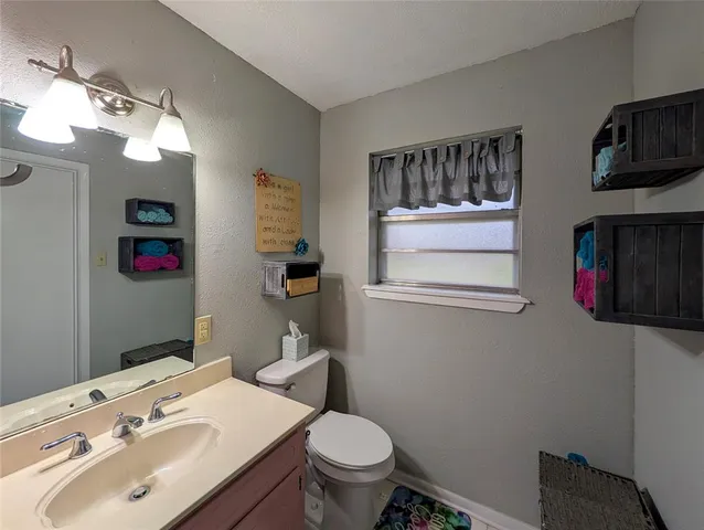 a bathroom with a sink vanity mirror and toilet