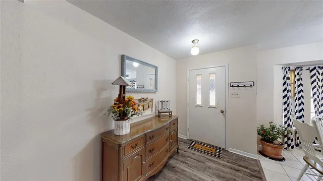 a hallway with painting on the wall and a potted plant