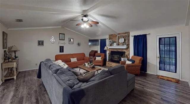 a living room with furniture a ceiling fan and a window
