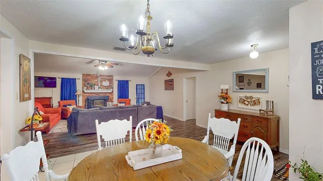 a living room with furniture kitchen view and a wooden floor