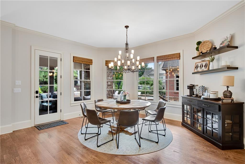 13942 Tree Loft Road Milton, GA 30004 - Photo 22 of 102 a dining room with furniture a chandelier and wooden floor