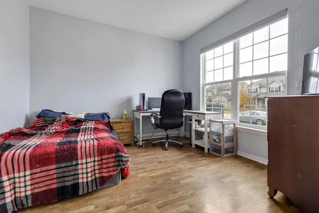 a bedroom with a bed and a large window