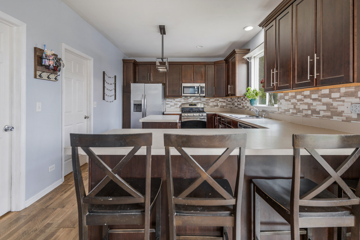 1157 Clearwater Drive Pingree Grove, IL 60140 - Photo 30 of 34 a kitchen with a dining table chairs and cabinets