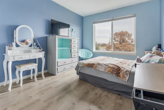 a bedroom with a bed a fireplace and a large window
