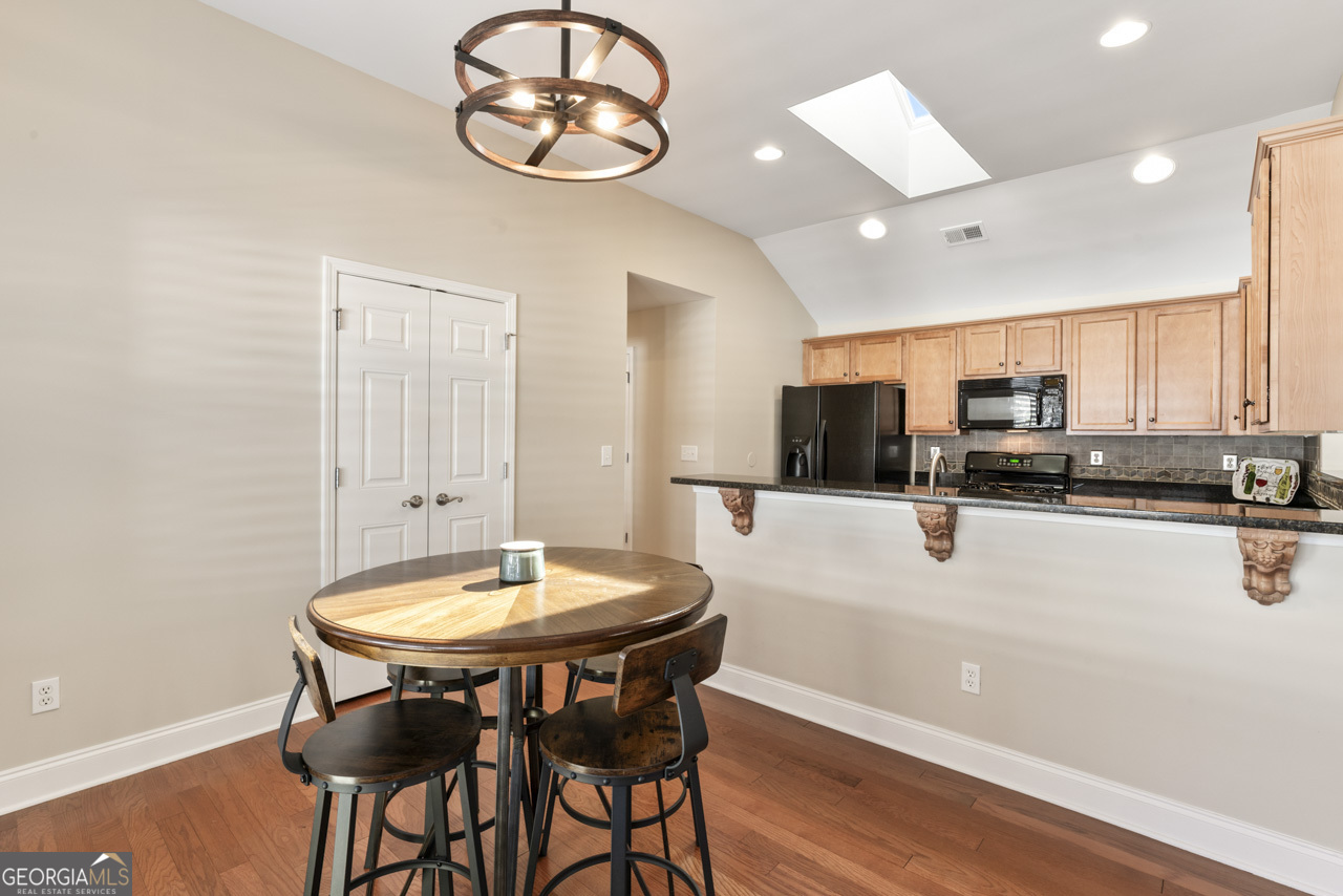 100 Cottage Club Drive Locust Grove, GA 30248 - Photo 12 of 42 a kitchen with stainless steel appliances a table and chairs in it