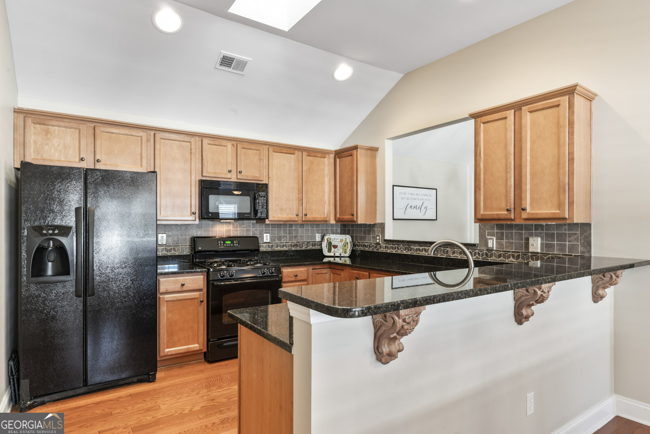 100 Cottage Club Drive Locust Grove, GA 30248 - Photo 14 of 42 a kitchen with granite countertop a sink a counter top space stainless steel appliances and cabinets