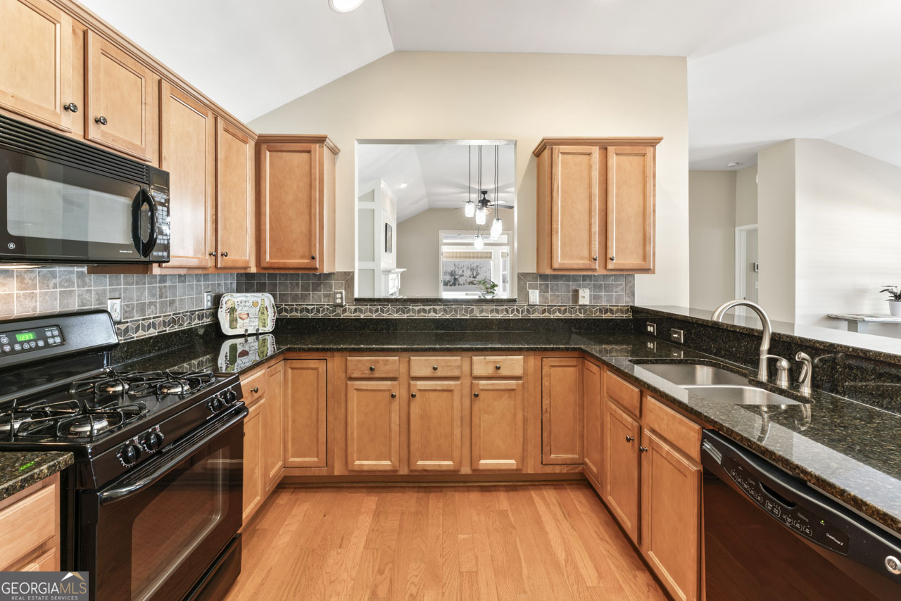 100 Cottage Club Drive Locust Grove, GA 30248 - Photo 15 of 42 a kitchen with stainless steel appliances granite countertop a stove a sink and a microwave