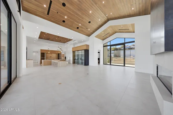 a large living room with stainless steel appliances kitchen island granite countertop a large window and a couch