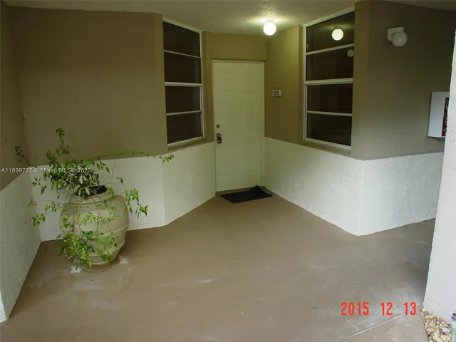a view of a hallway with wooden floor and a bathroom