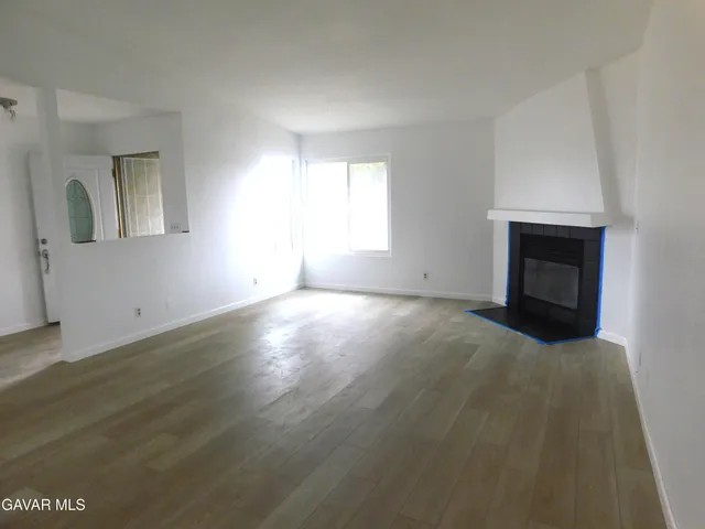 an empty room with windows and fireplace